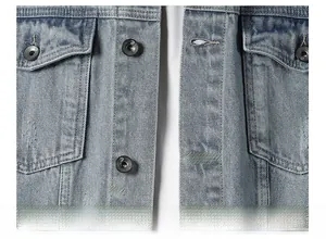 Macro detail of washed light blue denim jacket with metallic buttons and flap pocket
