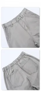 Detail of vintage grey washed cargo pants showing elastic waistband and button fly