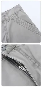Detailed view of light grey cargo pants showing metal zipper and twill fabric texture