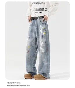 Close-up of wide-leg jeans featuring heavy-wash denim with white paint splatter and distressing