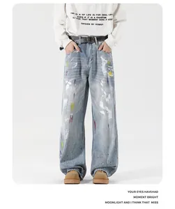 Detail of light blue washed denim jeans featuring artistic colorful paint splatter design