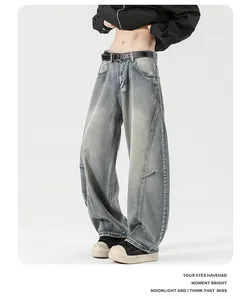 Detail view of washed blue retro baggy jeans with black leather belt and side stitching