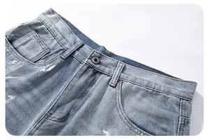 Macro detail of vintage light blue washed denim jeans with metal button and white speckles