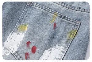 Macro shot of street-style graffiti paint splatters on light blue denim jeans back pocket
