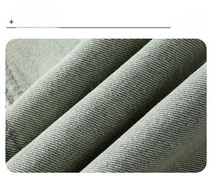 Macro shot of washed gray-blue denim fabric with durable twill texture and brown stitching