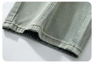 Close-up detail of double-stitched hem on vintage washed wide-leg denim trousers