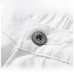 Macro detail of elastic waistband and vintage metal button on white cotton trousers