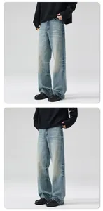 Detailed view of washed light blue denim jeans with vintage whiskering and distressed texture