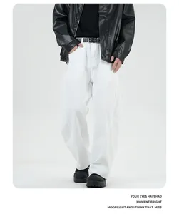 Detail view of American vintage washed wide-leg jeans with knee paneling and leather belt