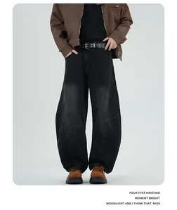 Close-up of vintage washed gray wide-leg jeans with curved stitching and industrial style