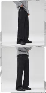 Detailed side view of thick black denim fabric and heavy stitching on straight leg pants