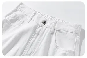 Detail of white denim pants showing elastic waistband and dark grey metal button closure