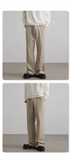 Detail showing khaki flared trousers with front crease and smooth drape texture