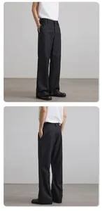 Detail view of black wide-leg trousers showing draped fabric and tailored side pockets