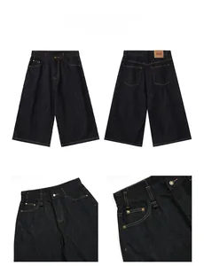 Detail display of deep blue washed denim wide-leg shorts with contrast stitching and leather patch
