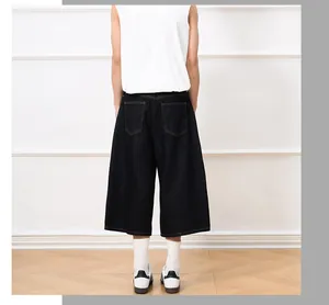 Rear view of dark denim wide-leg cropped jeans styled with white sneakers and socks