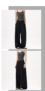 Dettaglio dei pantaloni neri a vita alta con gamba larga e pieghe fluide dal design fluido