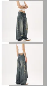 Vue détaillée du jean bleu délavé rétro avec moustaches usées et écusson en cuir à la taille