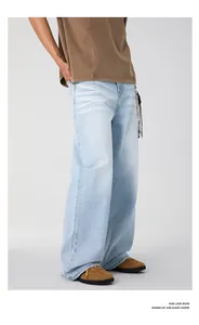 Macro view of light blue straight-leg denim jeans with washed cat-whisker texture