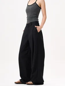 Pantaloni neri a gamba larga con pieghe e drappeggio fluido indossati da modella