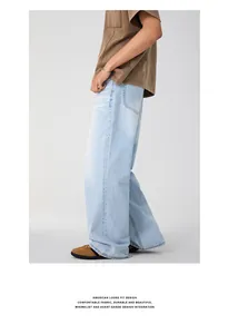 Side view of men's loose fit light blue washed denim jeans with vintage faded effect