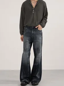 Deep grey knit long-sleeve polo paired with washed wide-leg flared denim jeans