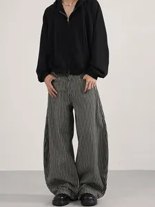 Retro striped wide-leg trousers paired with a black zip hoodie for a relaxed urban style