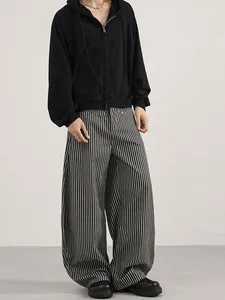 Men's relaxed fit vertical stripe loose pants styled with a black hoodie and leather shoes