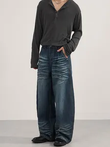 Men's loose fit dark blue jeans with vintage whiskering effect and straight leg cut
