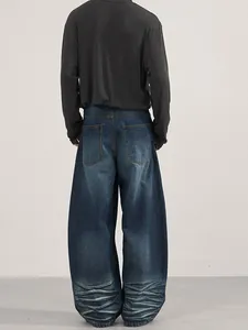 Relaxed fit dark blue washed denim jeans with unique distressed hem detail for men