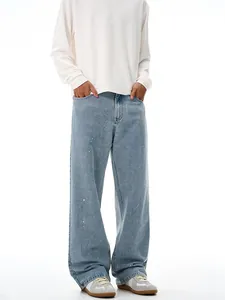 Relaxed fit light blue denim jeans with vintage wash and unique paint splatter design