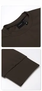 Détail de la texture côtelée marron foncé et des poignets ajustés sur un t-shirt boxy