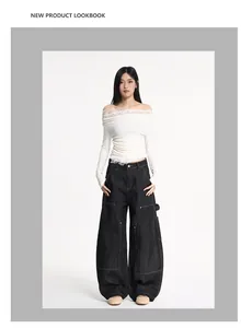 Asian model wearing white off-shoulder lace top and baggy black carpenter jeans with yellow stitching