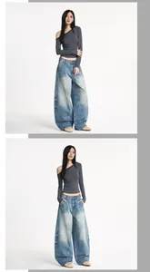 Détail du jean baggy délavé et du haut rayé à épaules dénudées porté par un mannequin