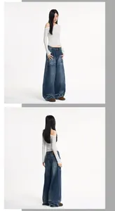 Detail einer dunkelblauen Baggy-Vintage-Jeans mit Cat-Whisker-Waschung und Streifen-Top