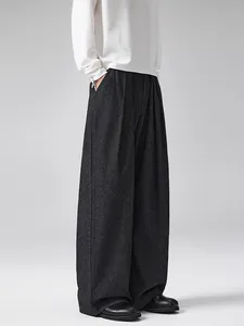 Dark grey pinstripe wide-leg trousers with elegant drape and minimalist loose fit
