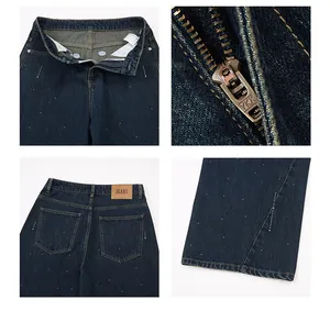 Detail der dunkelblauen Jeans mit Strass-Regentropfen und braunem Lederetikett am Bund