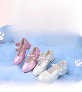 Detail of girls Mary Jane dress shoes with pearl straps and large side bows on soft soles