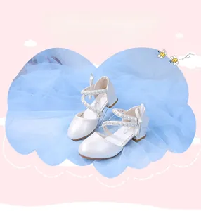 Close-up of pearl white girls' princess shoes with bow detail and pearl cross straps