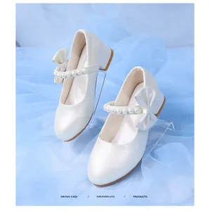 Detailed macro view of white pearl Mary Jane girl shoes with bow and pearl strap
