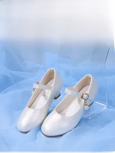 Détail de chaussure Mary Jane crème avec boucle dorée et pendentif en perle élégant