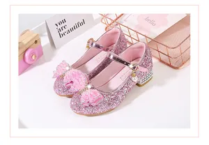 Macro detail of pink sequin girl's Mary Jane shoes with pearl bow and rhinestone heel