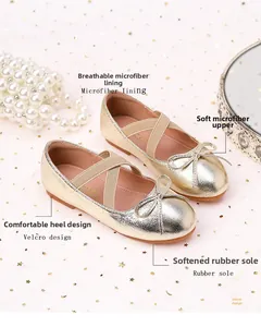 Detail of champagne gold girls Mary Jane shoes with bow and star glitter background