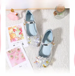 Détail de chaussures de princesse argentées avec paillettes, fleur de cristal et perle