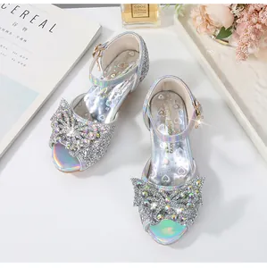 Close-up of sparkling silver girls' sandals with rhinestone bow and glitter finish