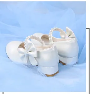 Detail view of girls white pearlized mary jane shoes with bow and low block heel