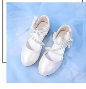 Top view of white pearl girl shoes featuring cross straps and elegant pearl embellishments