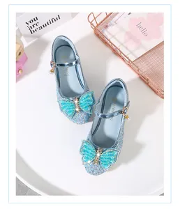 Detail of light blue sequined Mary Jane shoes with rhinestone butterfly and pearl charms