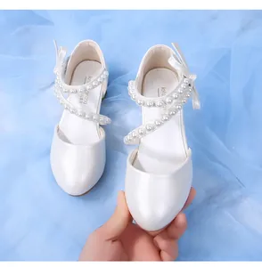 Detail of pearlescent white girls' princess shoes with pearl straps and bow accent