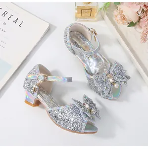 Detalle de zapatos de princesa plateados con purpurina y lazo de perlas para niña
